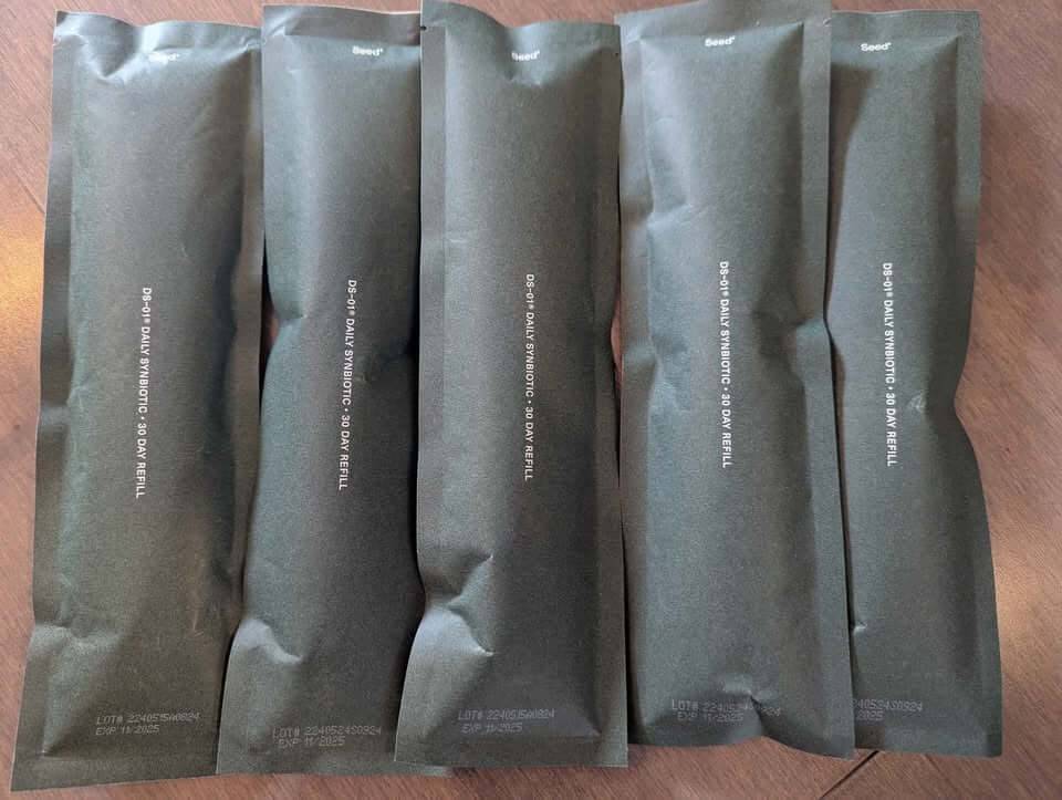 A person preparing to take their daily supplement, comparing seed vs athletic greens.