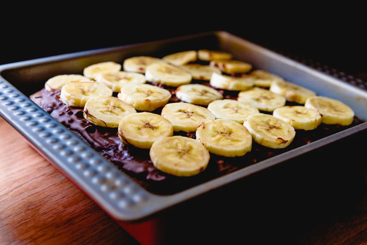 a tray of banana slices on top of a brownie