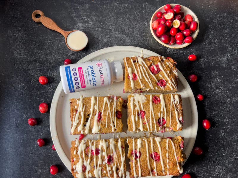 a plate of food with cranberries and a bottle of probiotic